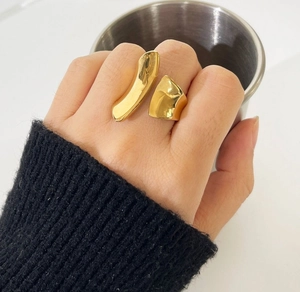 Detailed close-up of a wide polished 18K gold titanium steel open ring on a hand