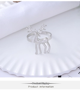 Close-up of a silver reindeer napkin ring on a white plate for Christmas table decor