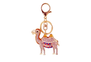 Close-up of golden camel keychain with purple rhinestones and colorful enamel details
