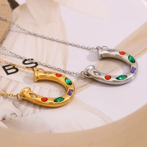 Detail of horseshoe pendants in gold and silver finish with colorful inset crystals