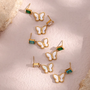Macro shot of butterfly earrings with colorful cubic zirconia on a pink stone background