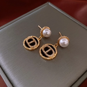 Macro shot of gold-plated pig nose pearl earrings with shimmering pavé crystal details