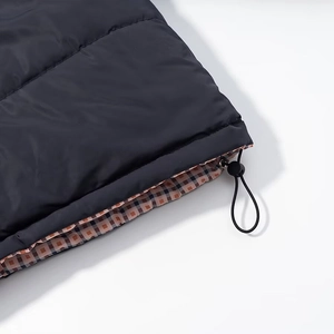 Close-up of black padded jacket hem with plaid lining and adjustable drawstring toggle