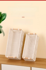 Detail of woven cotton rope storage baskets with wooden handles in cream white color
