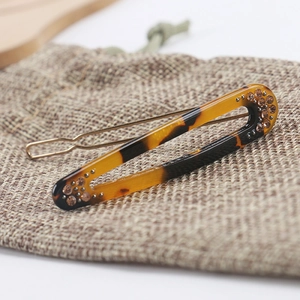 Macro view of leopard print acetate hair clip with crystal accents and metal backing