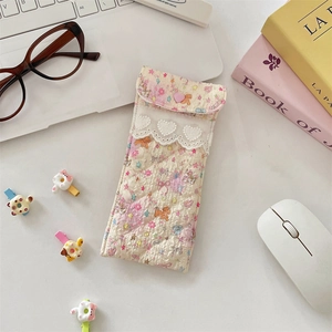 Close-up of floral quilted padded glasses pouch with white heart lace trim detail