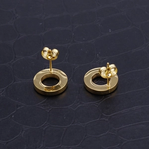 Detailed close-up of gold stainless steel hollow round earrings on a dark textured background