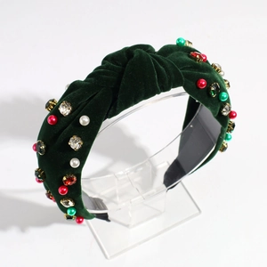 Close-up of green velvet knotted headband with pearls and crystal jewel embellishments