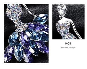 Detail of elegant ballerina brooch with blue and purple crystals on black leather