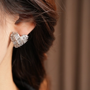 Détail macro du clou d'oreille cœur en zircone avec maille argentée et cristaux