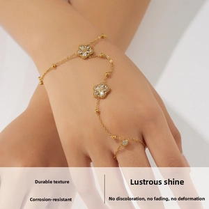Detail showing gold plated flower charms with clear zircon on the finger chain bracelet