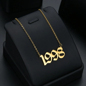 Minimalist gold stainless steel 1998 birth year pendant necklace on black display stand