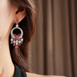 Detailed view of pink zircon butterfly drop earrings worn by a model in elegant style