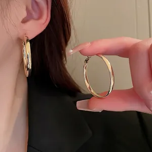 Grandes boucles d'oreilles créoles dorées minimalistes pour femmes au fini poli