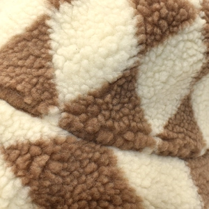Macro shot of brown and cream checkered sherpa fleece fabric texture on winter bucket hat