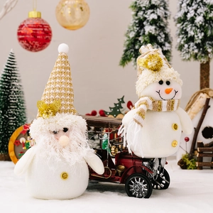 White snowman and Christmas gnome plush dolls on a red vintage toy car in snow scene