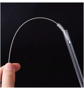 Flexible cleaning brush with white bristles demonstrating usage inside a glass straw