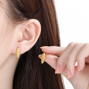 Exquisite gold feather stud earrings in titanium steel for women with metallic texture