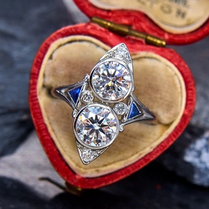 Vintage Art Deco ring with twin main stones and blue gems in a red heart gift box
