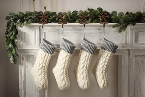 Close-up of four cable knit Christmas stockings hanging on a fireplace mantel