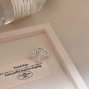Macro shot of silver beaded bow ring on jewelry box with elegant pearl texture finish