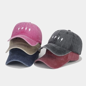 Macro shot of vintage washed cotton baseball caps with LOVE gesture embroidery details