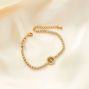 Elegant gold chain bracelet with sparkling crystal tree of life pendant on satin