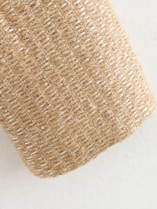 Macro shot of beige tweed fabric with metallic gold threads showing detailed texture