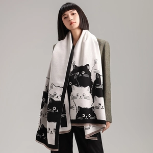 Detail of cute cat pattern on long thick knitted scarf with black and white color blocking