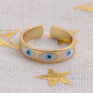 Dettaglio dell'anello regolabile dorato con tre motivi a occhio greco in smalto blu
