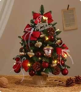 Detailed view of mini Christmas tree with red bows, ornaments, and pine cones for desktop decor