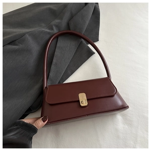 Detailed view of burgundy PU leather baguette bag featuring a gold twist lock and handle