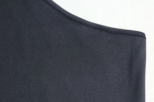 Close-up of high-quality stitching and black knitted fabric texture on backless dress