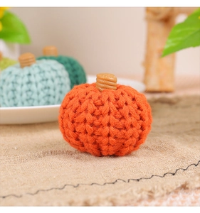 Close-up of orange knitted pumpkin with wooden stem for cozy autumn party decor
