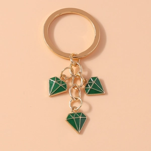 Detail of gold metal keychain with three green diamond-shaped oil-dripping pendants