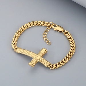 Gros plan du bracelet à maillons cubains dorés avec un détail de breloque croix