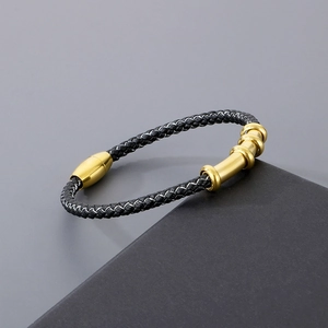 Detail of black braided leather bracelet with golden magnetic clasp and bamboo accents