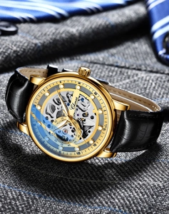 Macro view of men's skeleton mechanical watch with gold case on navy striped silk tie