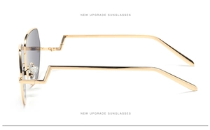 Detail view of gold aviator sunglasses featuring a geometric step-temple design and grey lenses