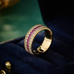 Detail of gold compass ring with red and clear zircon stones in a blue velvet box