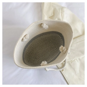 Detail view of handmade beige and grey woven cotton rope basket bag with knot accents