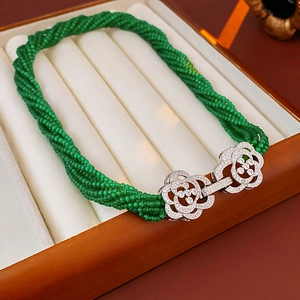 Detail of multilayer green bead necklace with silver camellia floral zircon clasp