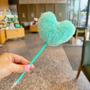 Cute mint green fluffy heart ballpoint pen with matching plastic barrel held in hand