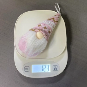 Dettaglio di uno gnomo natalizio in maglia fatto a mano dal peso di 12,3 grammi sulla bilancia