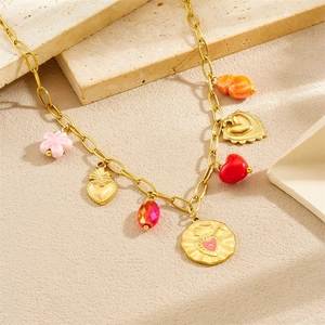 Gold stainless steel necklace with colorful resin heart and flower charms on stone surface