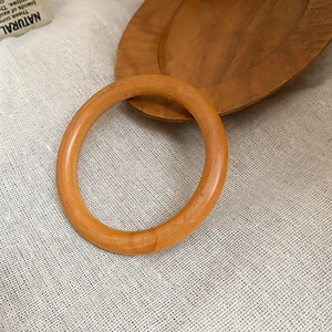 Détail de la texture naturelle du bois sur un bracelet poli jaune-brunâtre