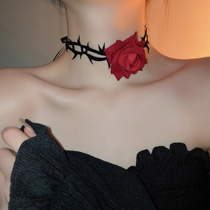 Makroaufnahme eines schwarzen Dornen-Chokers mit einer großen roten 3D-Stoffrose