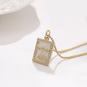 Golden necklace with square MAMA pendant featuring red lips and sparkling crystal border