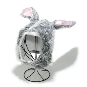 Detail of grey plush bunny hat with long ears and pink silk lining on a display stand