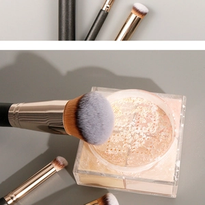 Detailed view of makeup brushes with grey gradient bristles and black golden handles